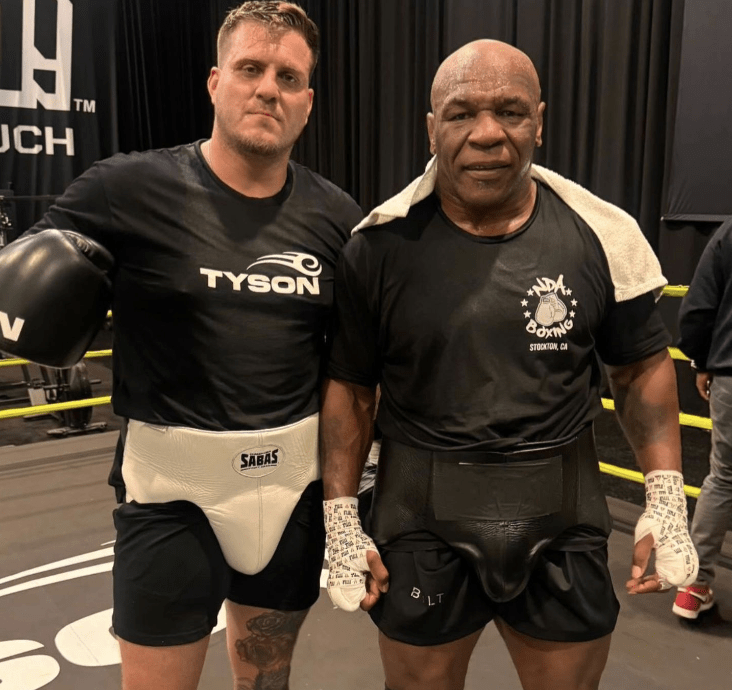 two men are posing for a picture and one is wearing a shirt that says tyson