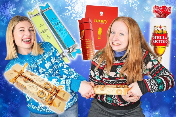 two women holding christmas crackers next to a bottle of stella artois