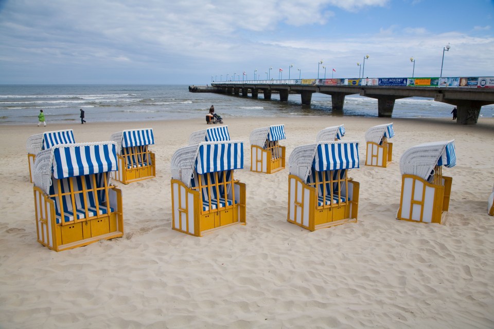 The beach at Kołobrzeg features colourful wooden deck chairs that are reminiscent of traditional seaside resorts in the UK