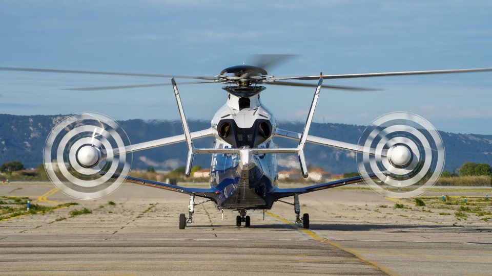 a helicopter is sitting on a runway with its propellers spinning