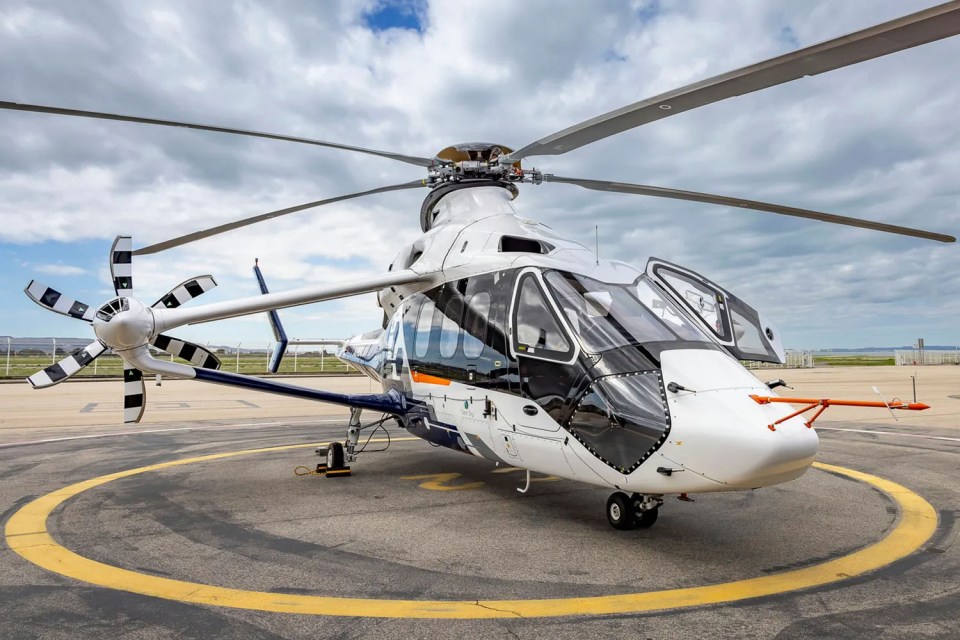 a white and blue helicopter is parked on a runway