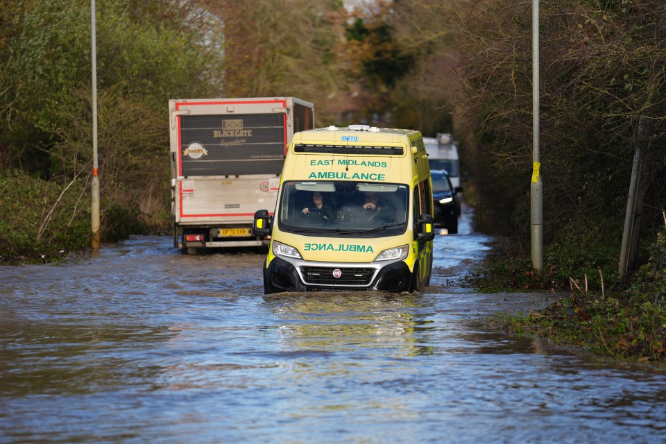 An ambulance drives through floodwater in Northamptonshire on Monday