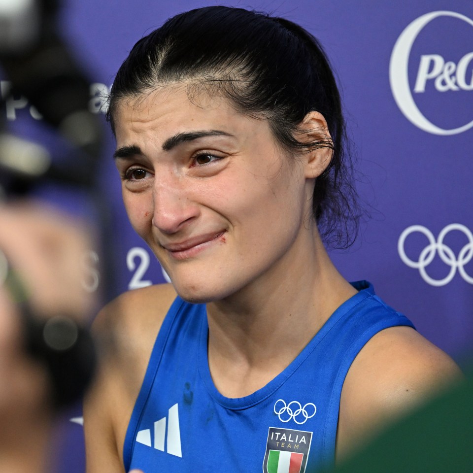 a woman wearing a blue italia shirt is crying