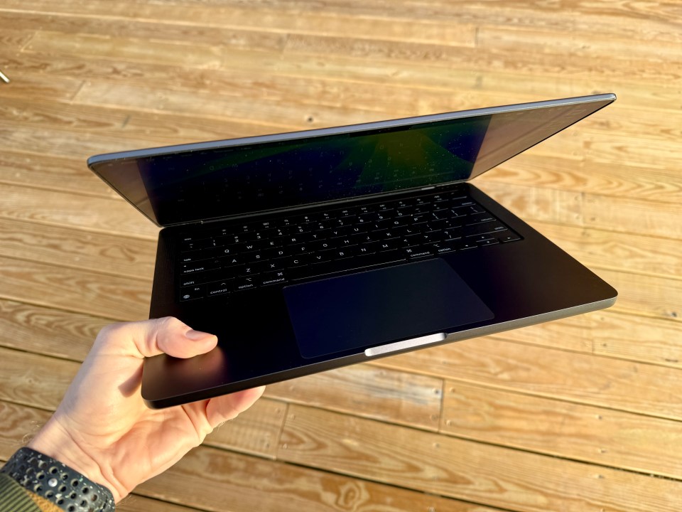 a person is holding a laptop that is open to the screen