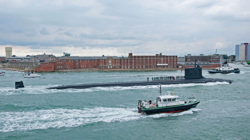 a submarine is being towed by a tug boat