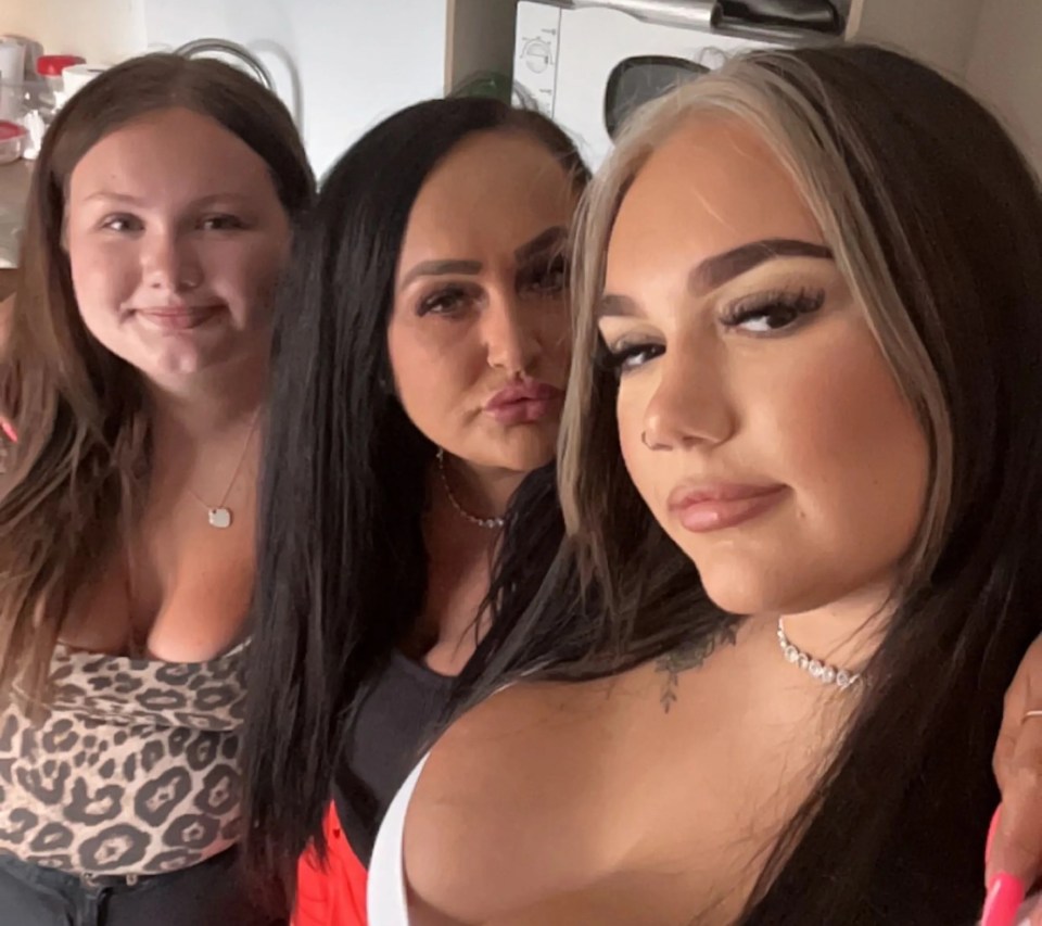 three women are posing for a picture in a kitchen