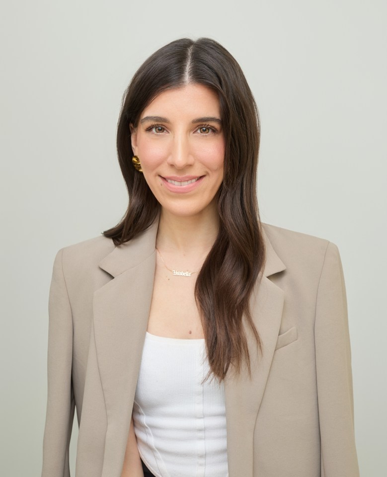 a woman wearing a tan jacket and a necklace that says ' samantha '