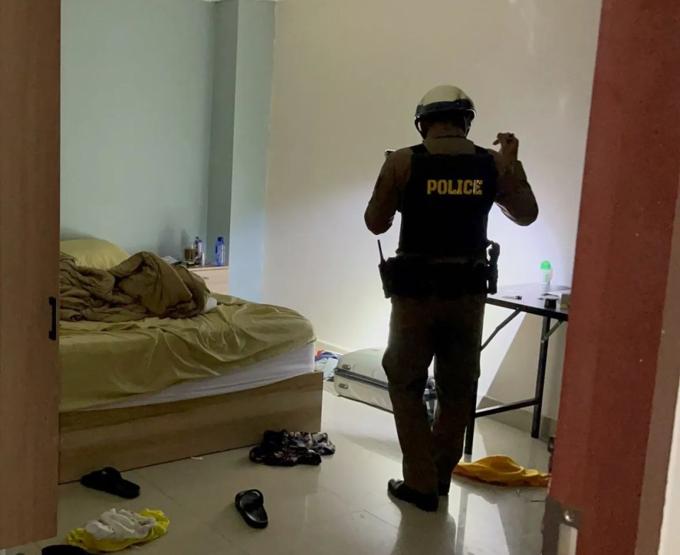 a police officer standing in a room with a bed