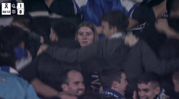 a crowd of people watching a soccer game with a score of 1 to 0