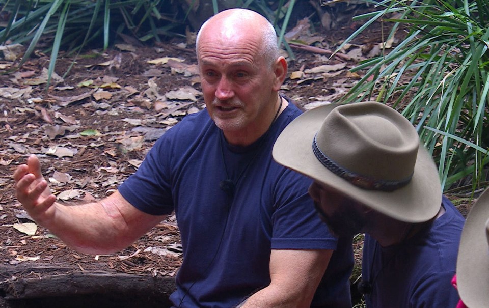 a man wearing a cowboy hat talks to another man