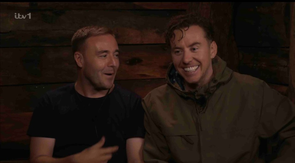 two men are smiling in front of a wooden wall with itv1 written on the bottom