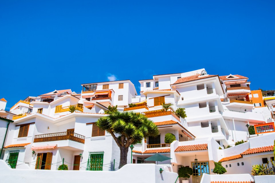 a row of white houses with red tile roofs