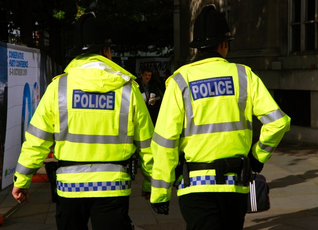 two police officers are walking down the street