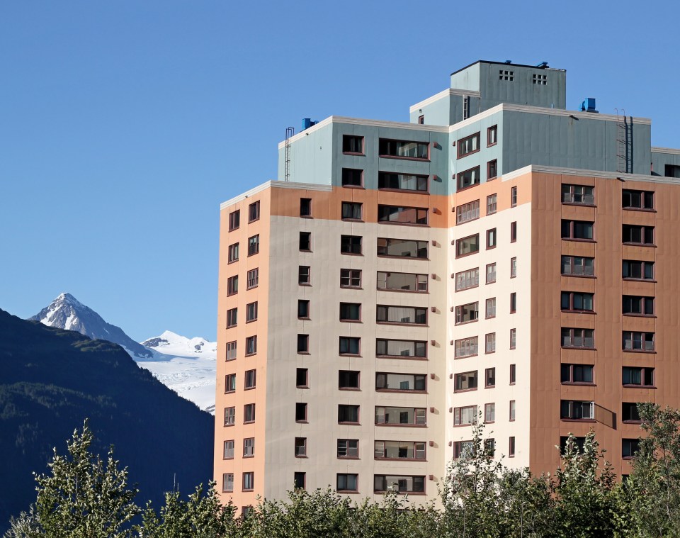 Multi-story building in Whittier, Alaska, with mountains in the background.