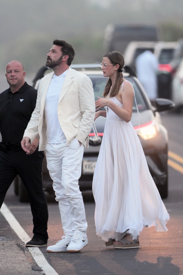 a man in a white jacket stands next to a woman in a white dress