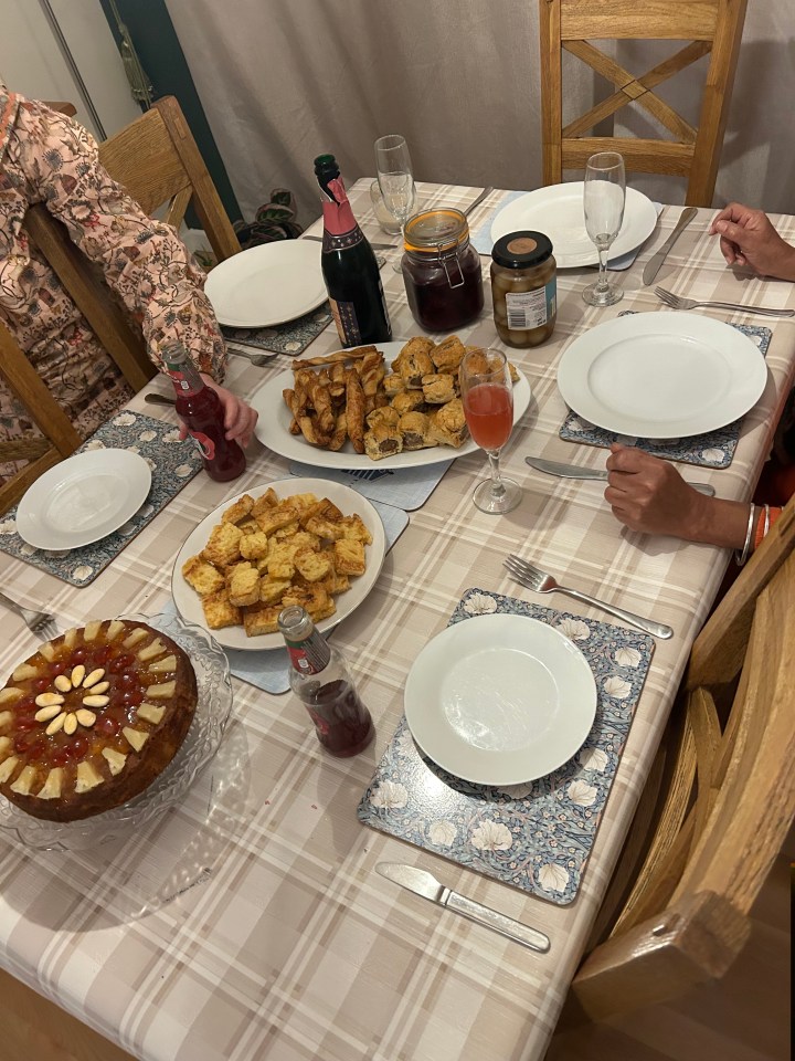 a bottle of coca cola sits on a table with plates of food