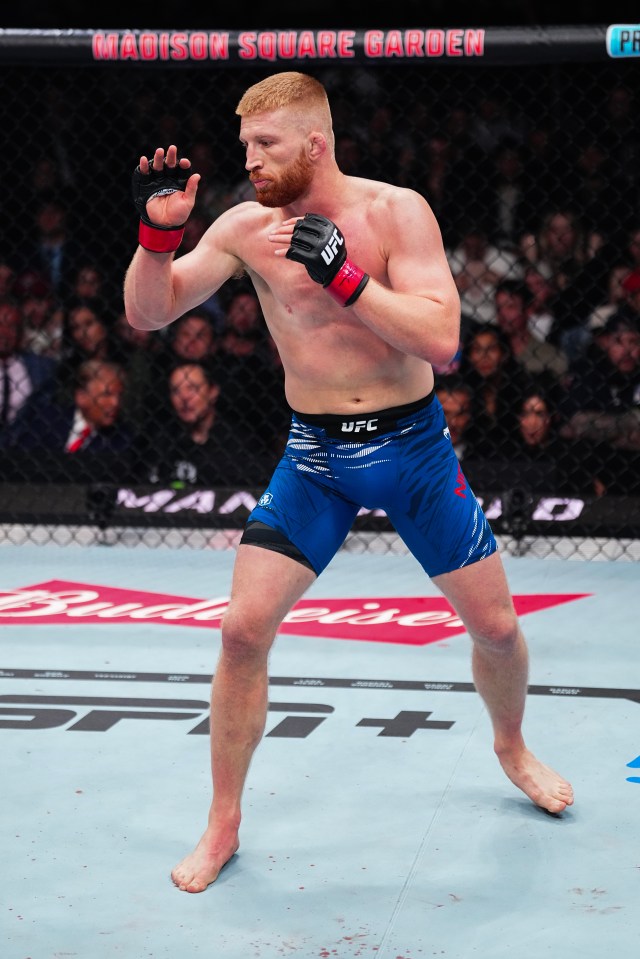 a man in a ufc uniform stands in front of a madison square garden banner