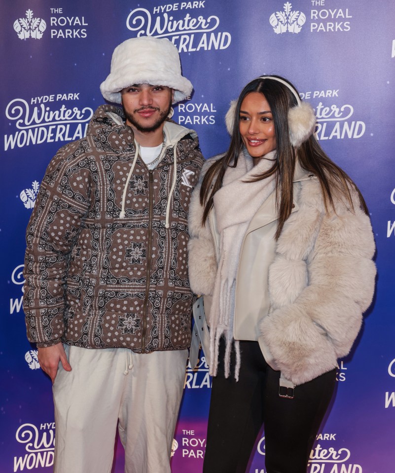 a man and a woman pose for a picture in front of a wall that says winter wonderland