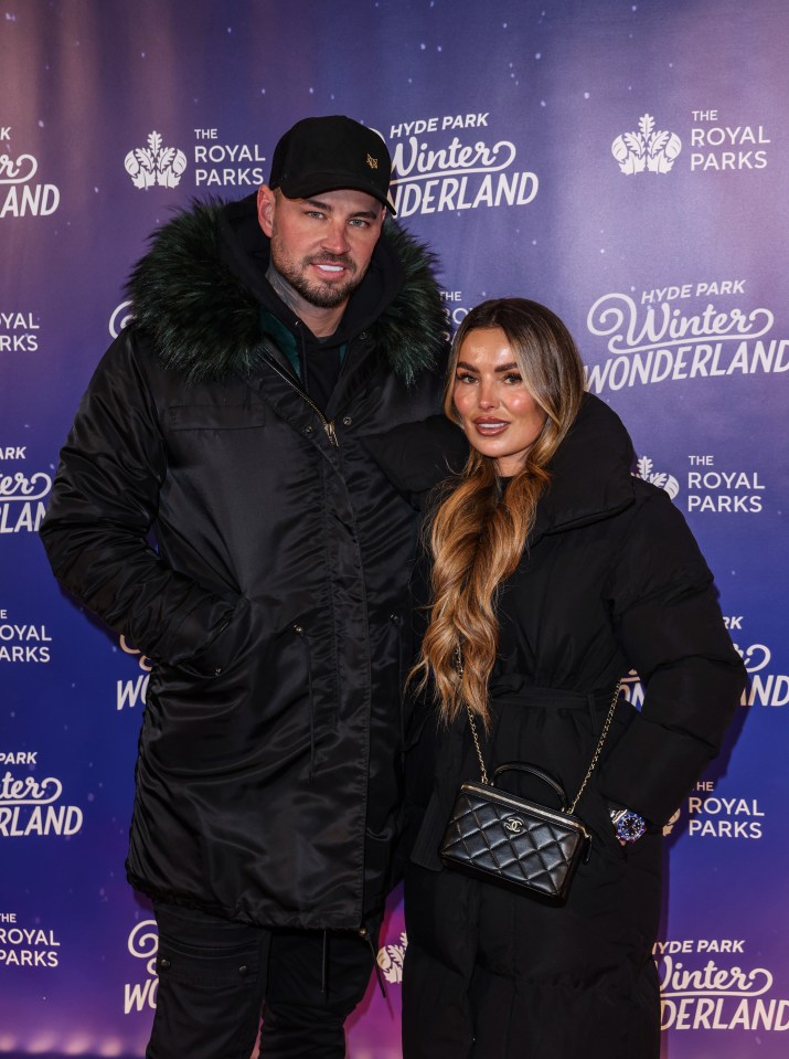 a man and woman are posing for a picture in front of a wall that says winter wonderland