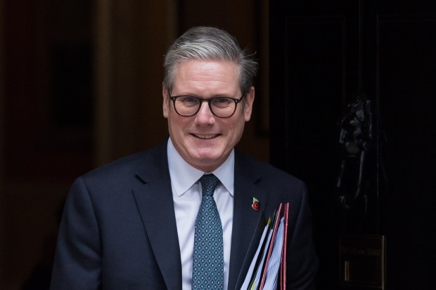 a man wearing glasses and a suit is smiling