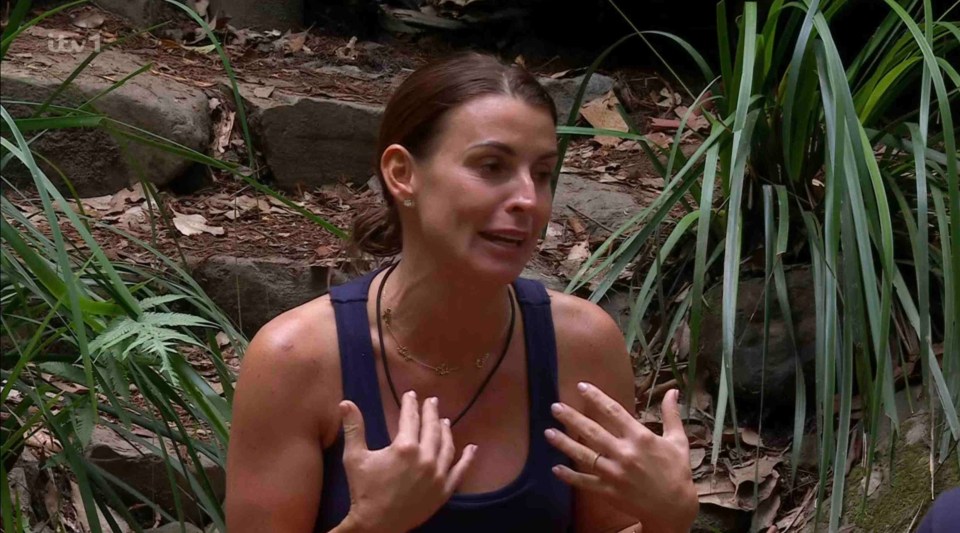 a woman in a blue tank top is talking in the jungle