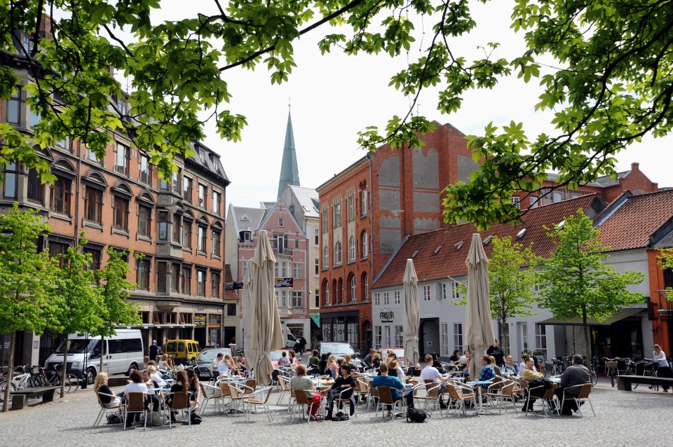 a group of people sit at tables in front of a building with a sign that says par