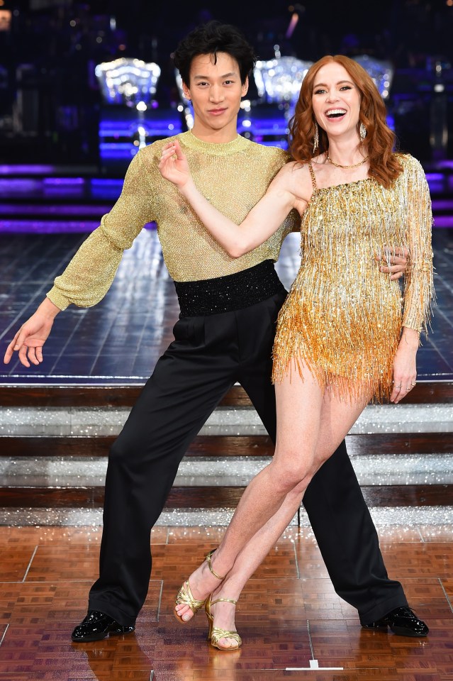 a man and a woman are posing for a picture on a dance floor