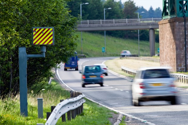 a car with a yellow license plate is driving down a road