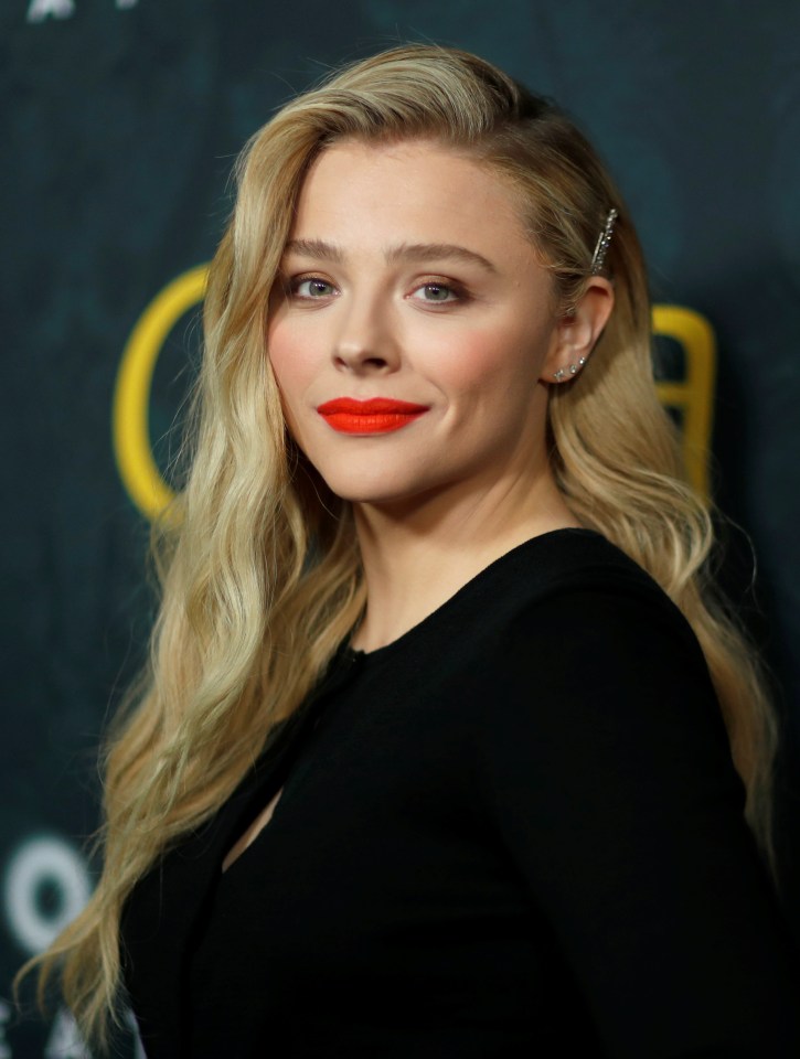 a woman wearing red lipstick and a black dress