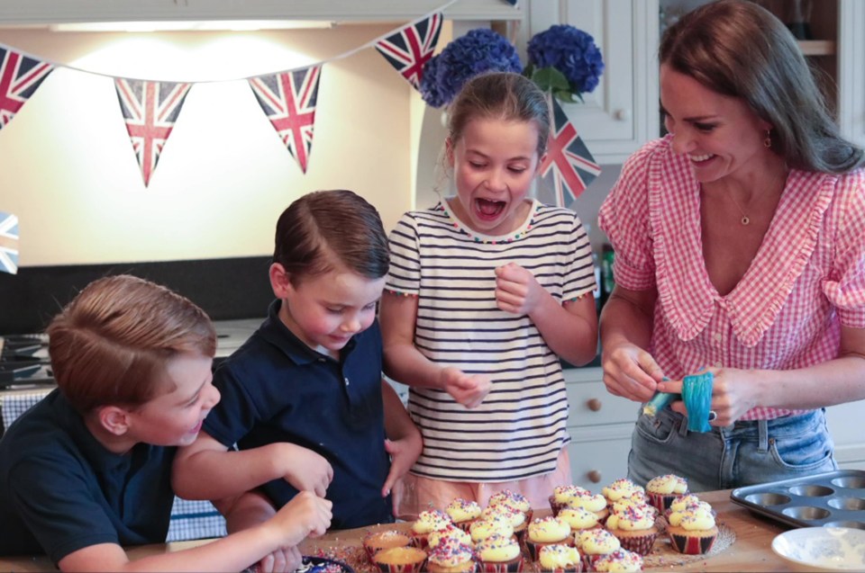 a woman and three children are decorating cupcakes with sprinkles