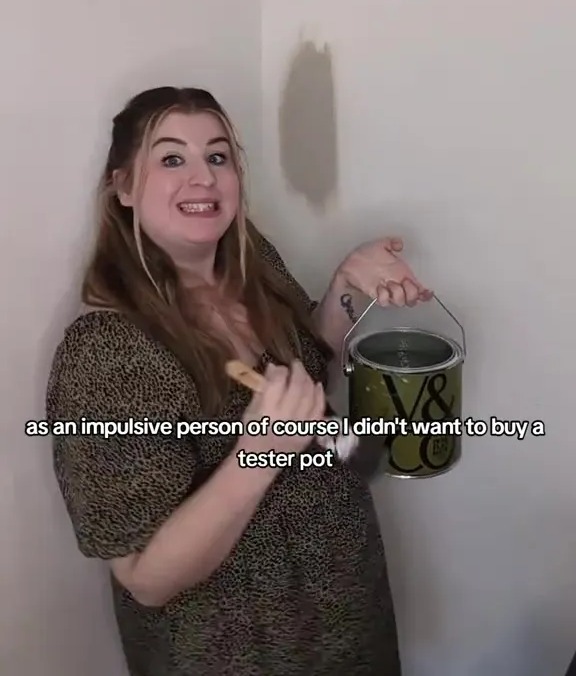 a woman is holding a bucket of v8 paint