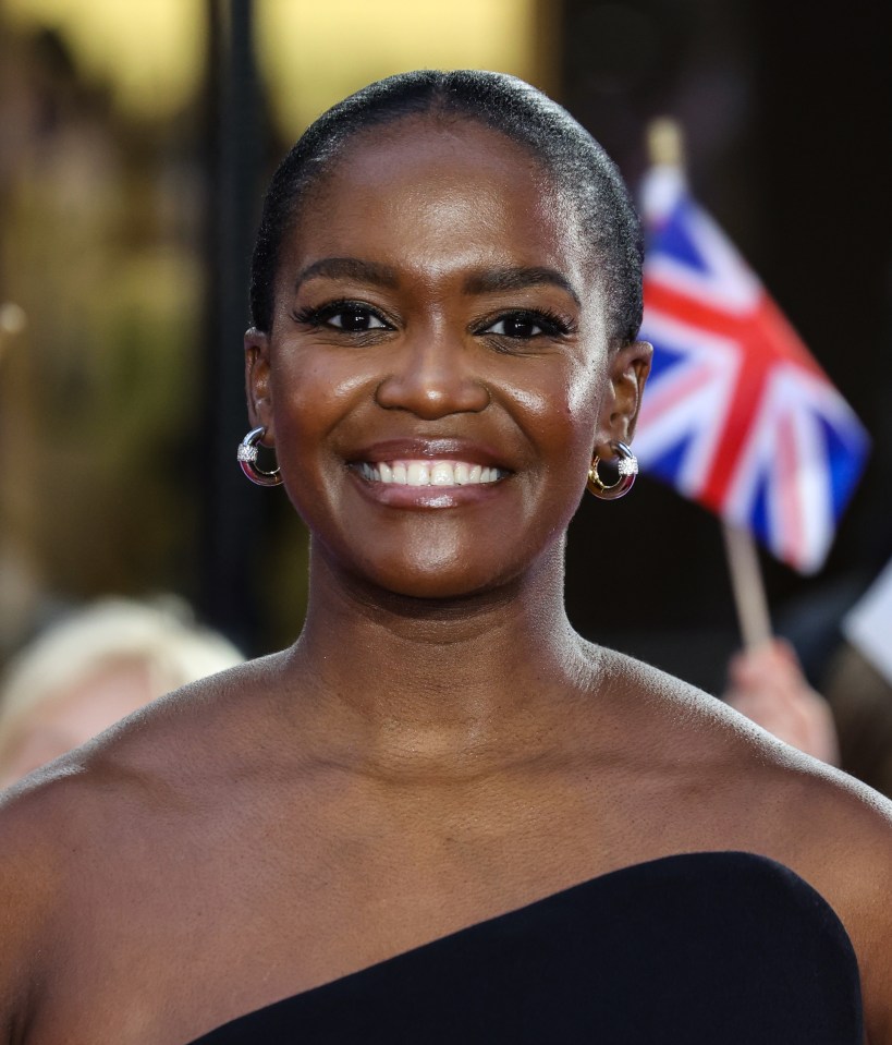 a woman in a black dress is smiling and holding a british flag