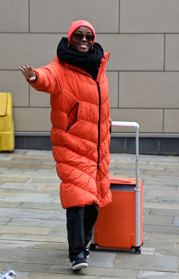 AJ Odudu bossing it in this bright orange puffer