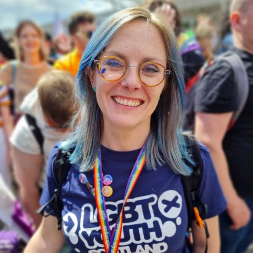 a woman wearing a blue shirt that says lgbt youth scotland