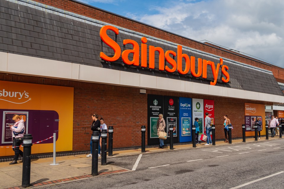 a sainsbury 's store with people standing outside