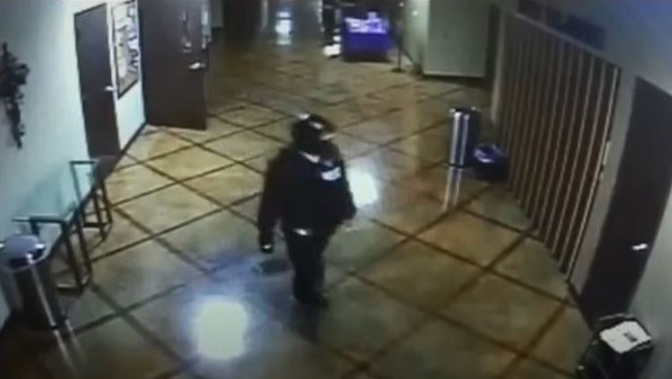 a man in a helmet is walking down a hallway in a building .