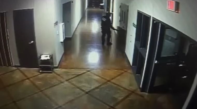 a man is walking down a hallway in a building .