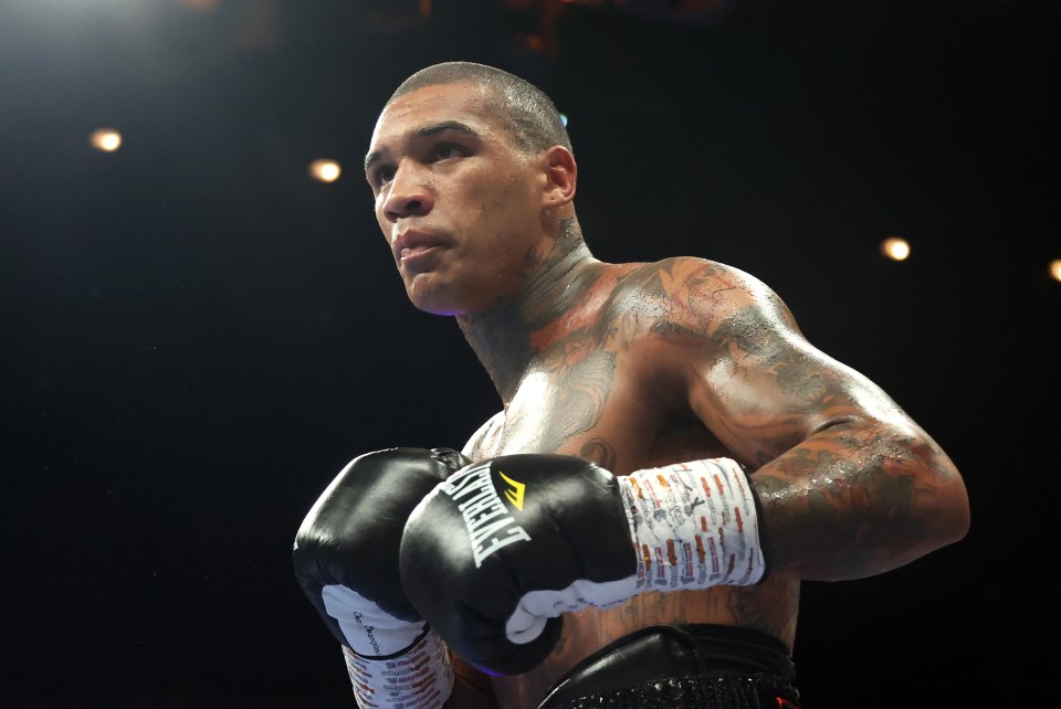 a man wearing everlast boxing gloves in a dark room