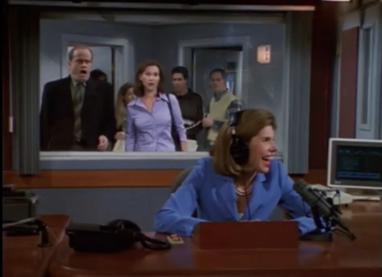 a woman wearing headphones is sitting at a desk in front of a microphone