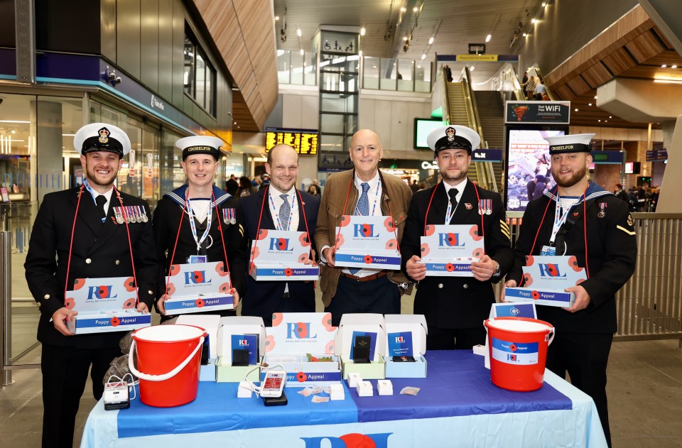 a group of men are standing around a table holding boxes with the letters rl on them