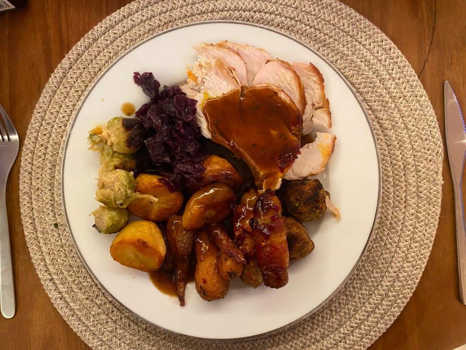 a white plate topped with turkey potatoes and vegetables