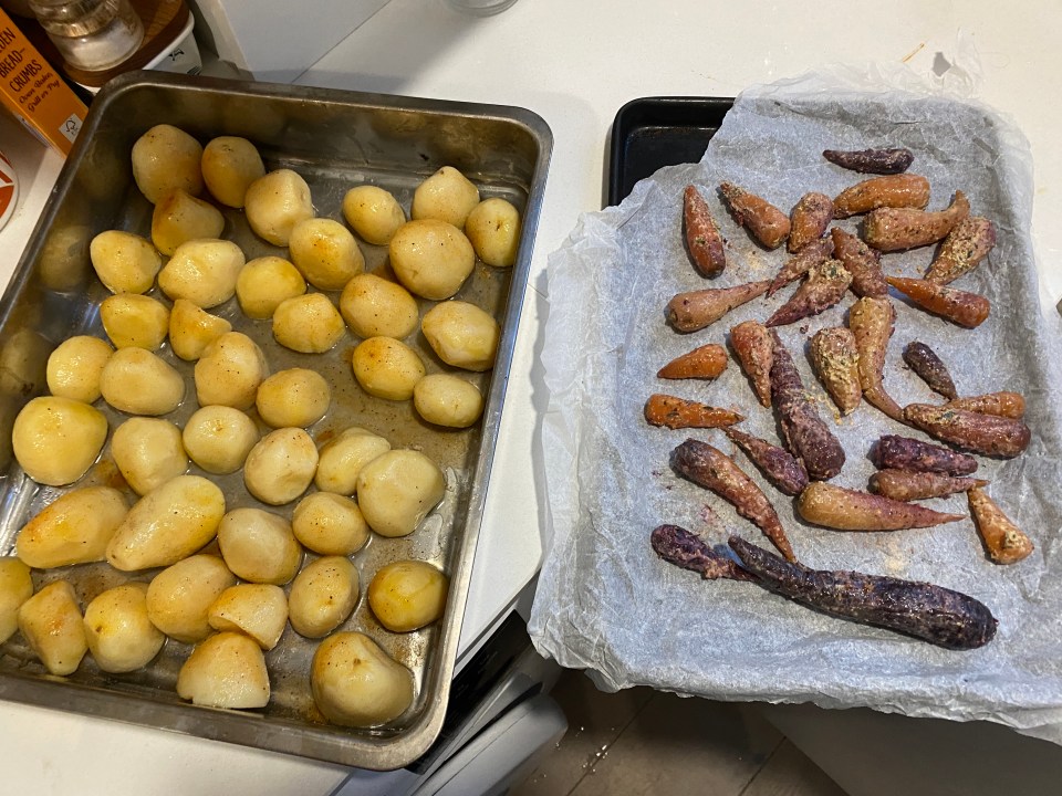 a tray of potatoes sits next to a tray of carrots