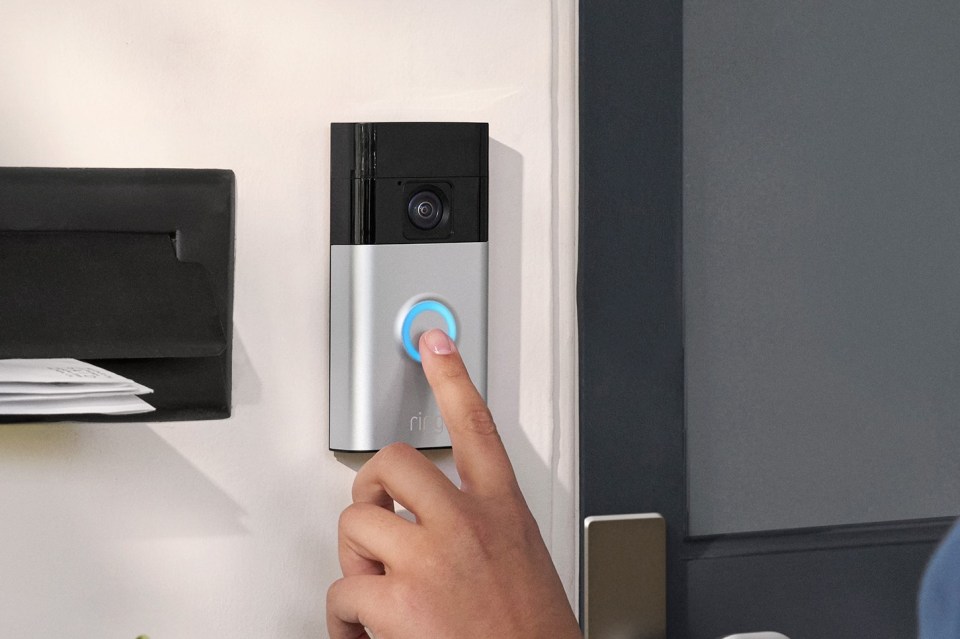 a person pressing a button on a ring doorbell