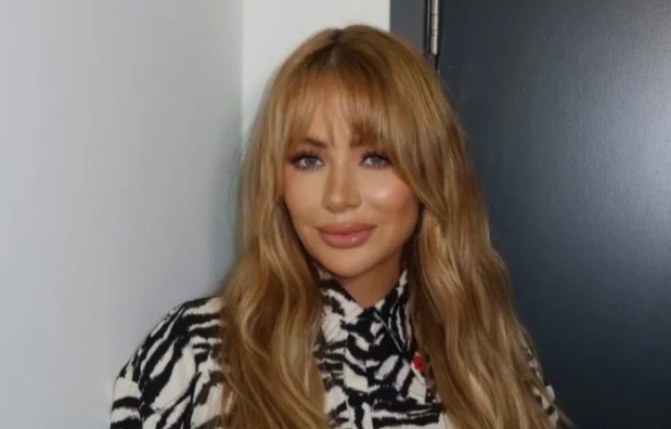 a woman in a zebra print shirt holds a cell phone