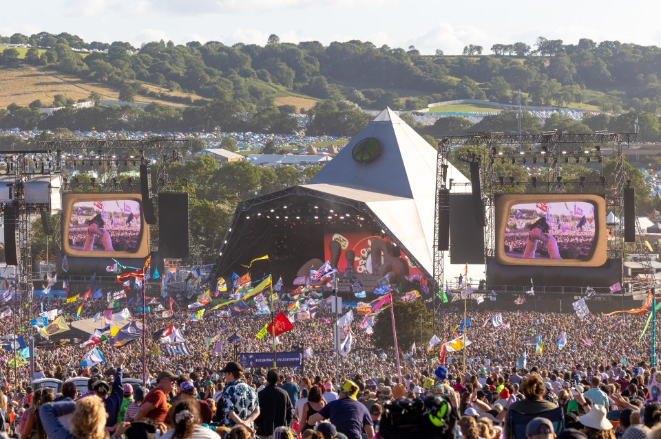 a large crowd of people are gathered at a music festival