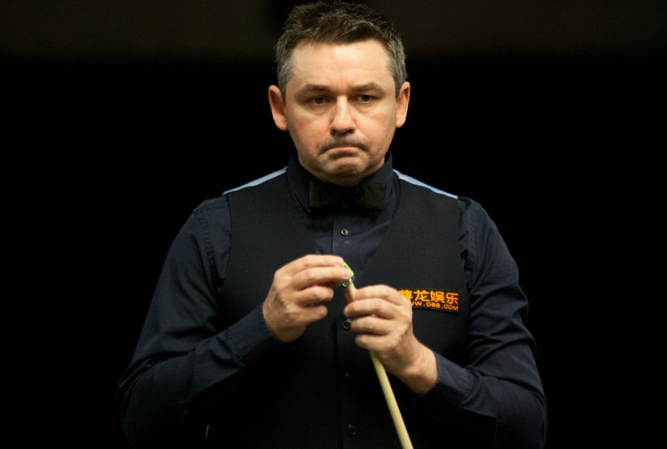 a man holding a snooker cue with chinese writing on his shirt