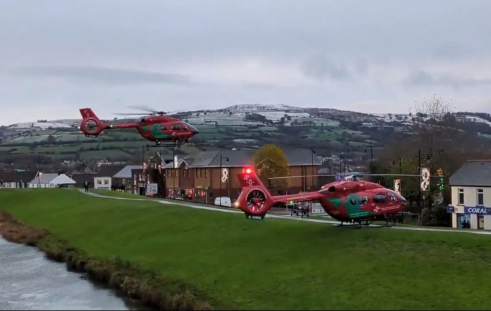 two red helicopters are parked in front of a building that says coral