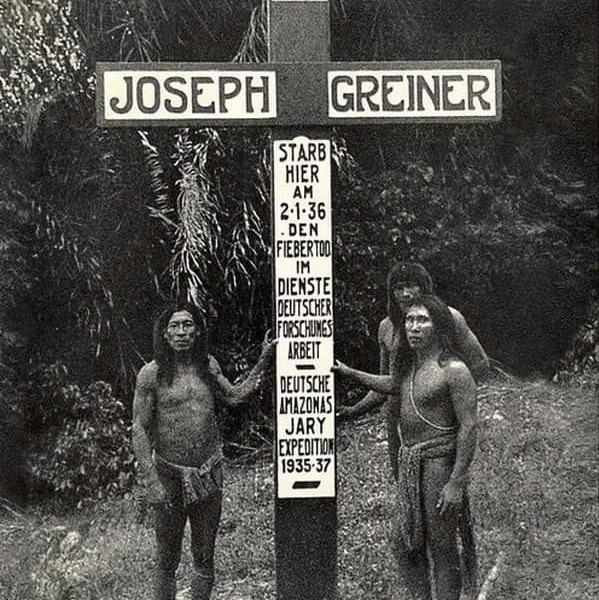 a group of men standing under a sign that says joseph greiner