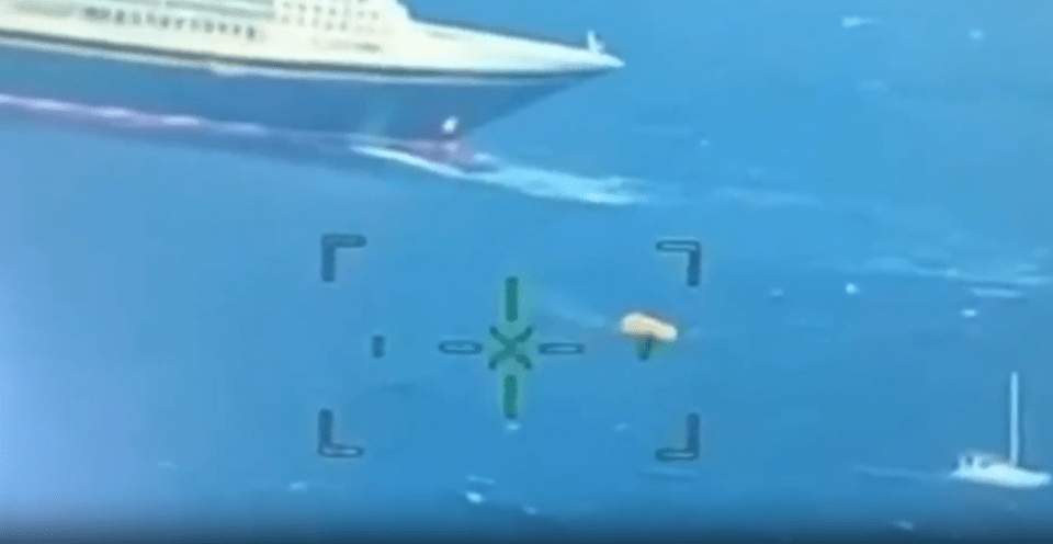 a ship is floating in the ocean with a target in the foreground