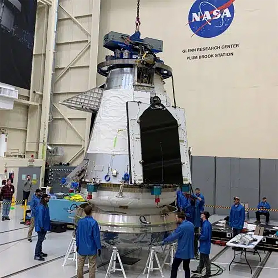 a group of people are working on a nasa rocket